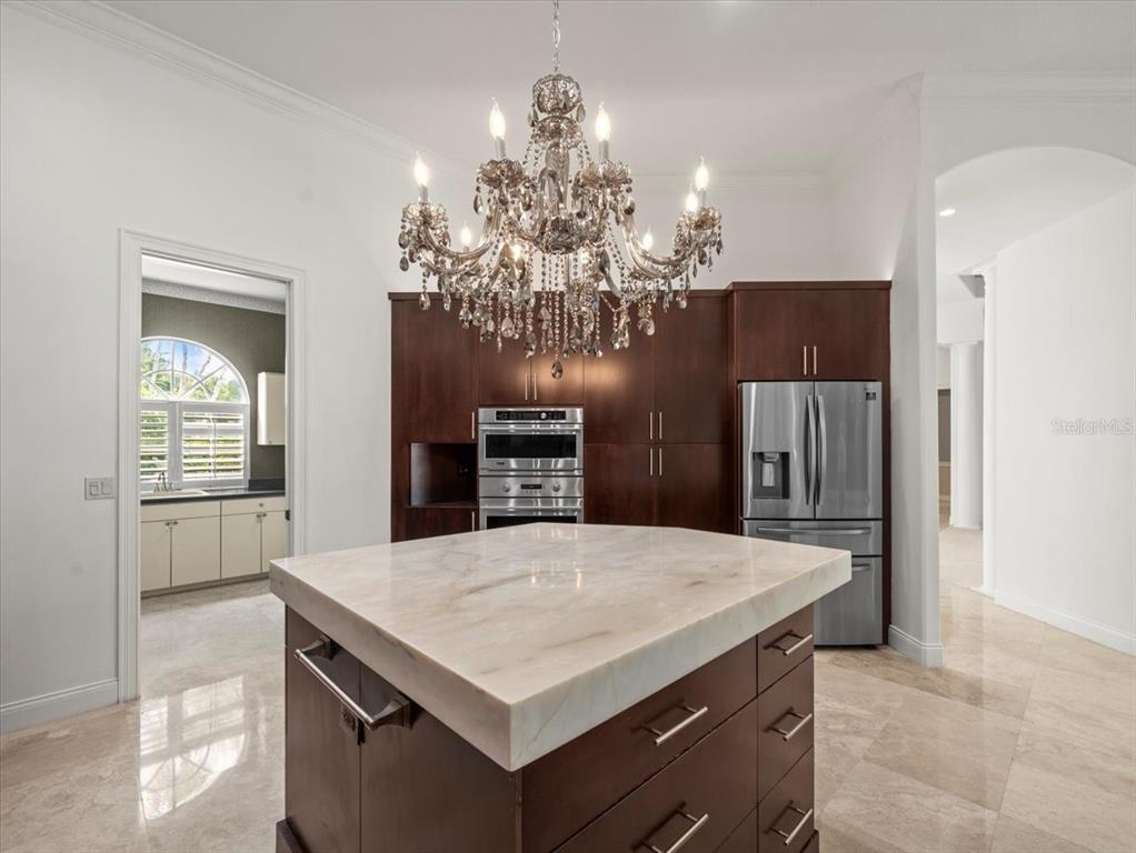 4529 Cheval Boulevard Lutz, FL 33558 - Photo 27 of 83 a kitchen that has a kitchen island and a refrigerator in it