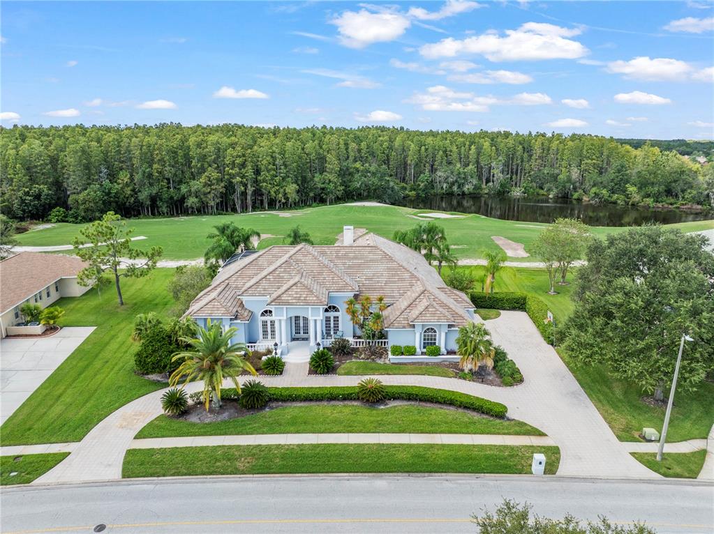 4529 Cheval Boulevard Lutz, FL 33558 - Photo 3 of 83 a view of a white house with a big yard plants and large trees