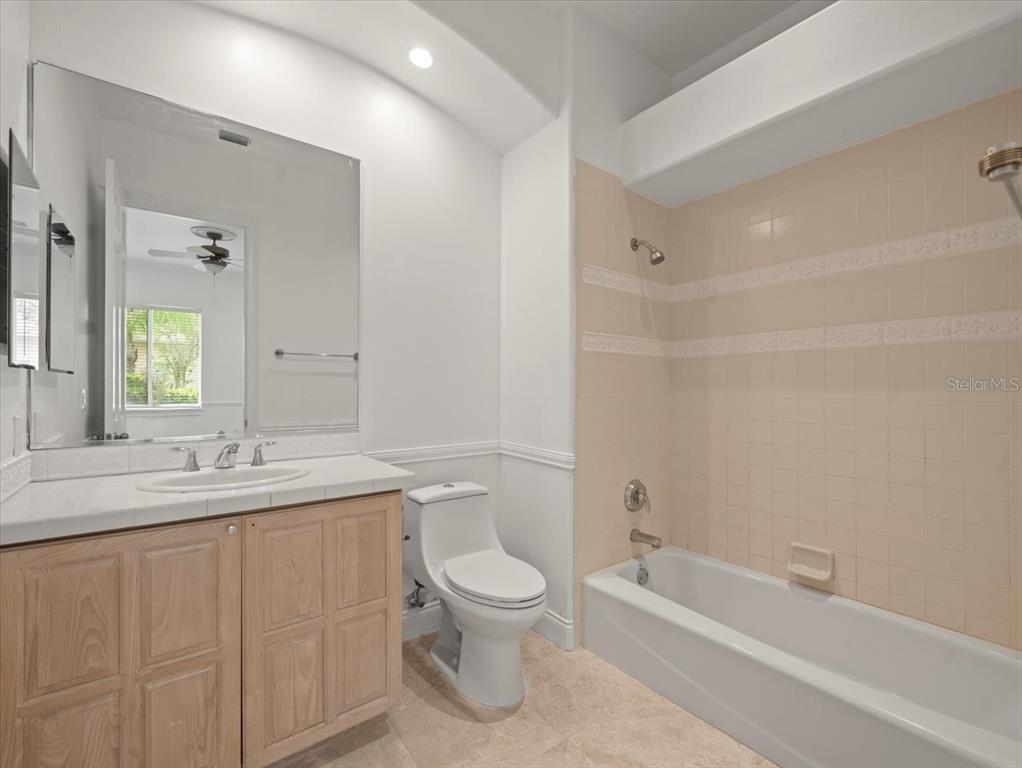 4529 Cheval Boulevard Lutz, FL 33558 - Photo 56 of 83 a bathroom with a granite countertop sink toilet a large mirror a bathtub and shower