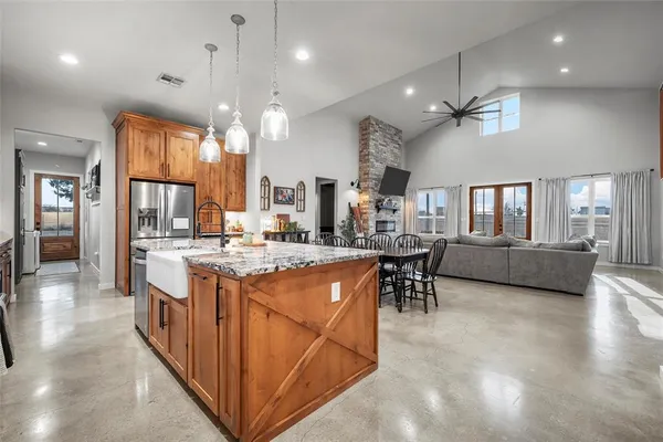 a kitchen with kitchen island a large counter space and stainless steel appliances