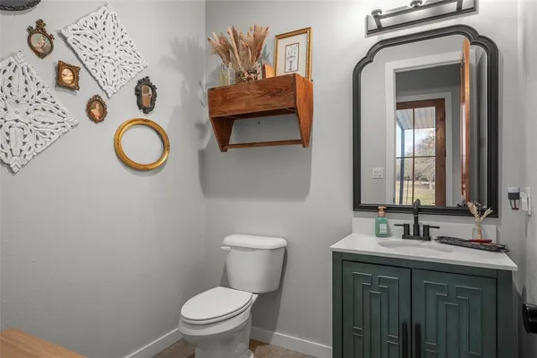 a bathroom with a granite countertop toilet sink and mirror