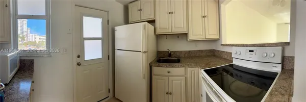 a kitchen with stainless steel appliances granite countertop a refrigerator and a stove