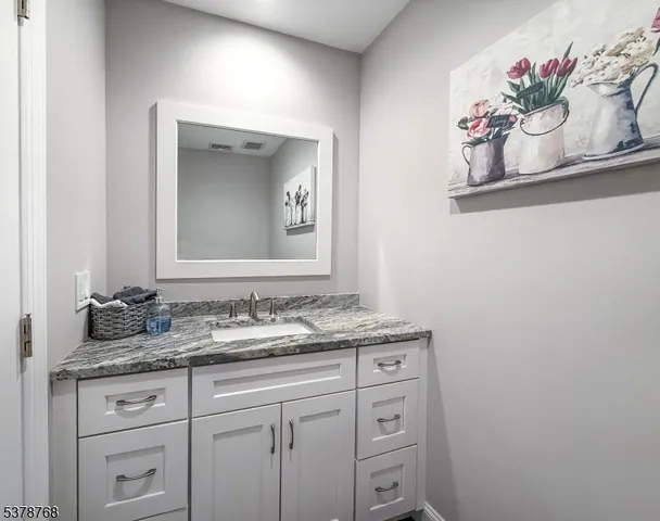a bathroom with a granite countertop sink and a mirror