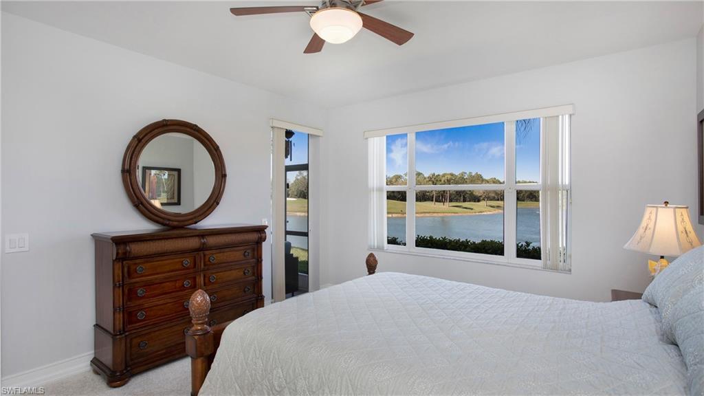 5705 Heron Lane, Unit 801 Naples, FL 34110 - Photo 11 of 32 a bedroom with a bed a mirror and a window