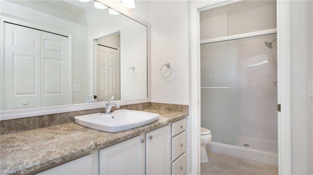 5705 Heron Lane, Unit 801 Naples, FL 34110 - Photo 12 of 32 a bathroom with a granite countertop sink and a mirror