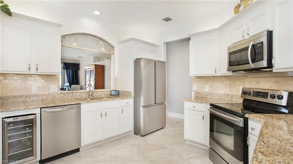5705 Heron Lane, Unit 801 Naples, FL 34110 - Photo 4 of 32 a kitchen with stainless steel appliances granite countertop a refrigerator stove and microwave