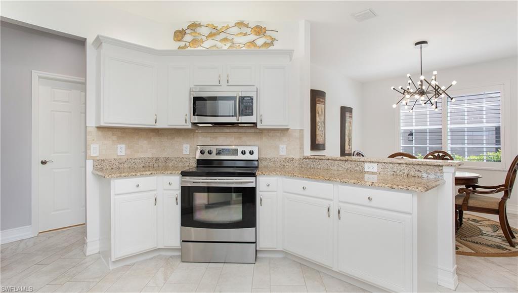 5705 Heron Lane, Unit 801 Naples, FL 34110 - Photo 7 of 32 a kitchen with stainless steel appliances granite countertop a stove sink and microwave