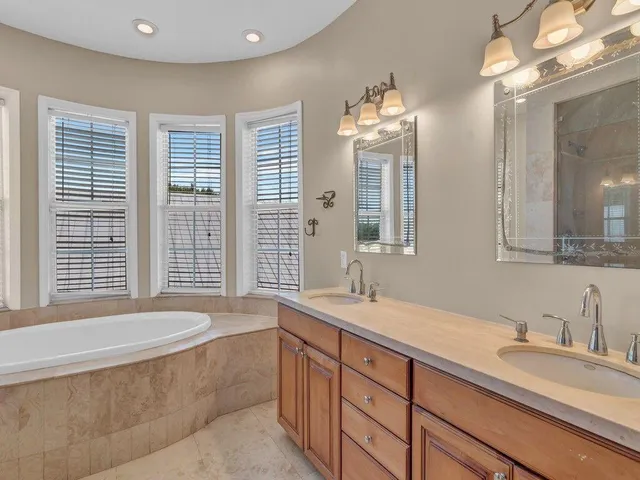 a bathroom with double vanity sinks and a bathtub