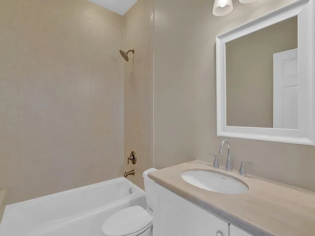 a bathroom with a granite countertop sink toilet and a mirror