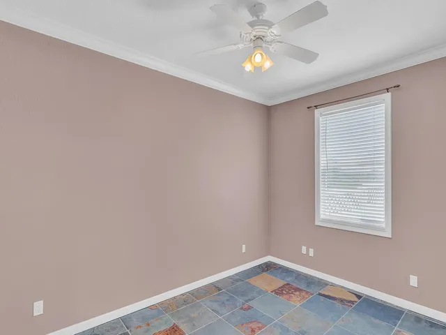 an empty room with window and ceiling fan