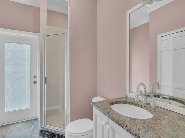 a bathroom with a granite countertop sink toilet and shower