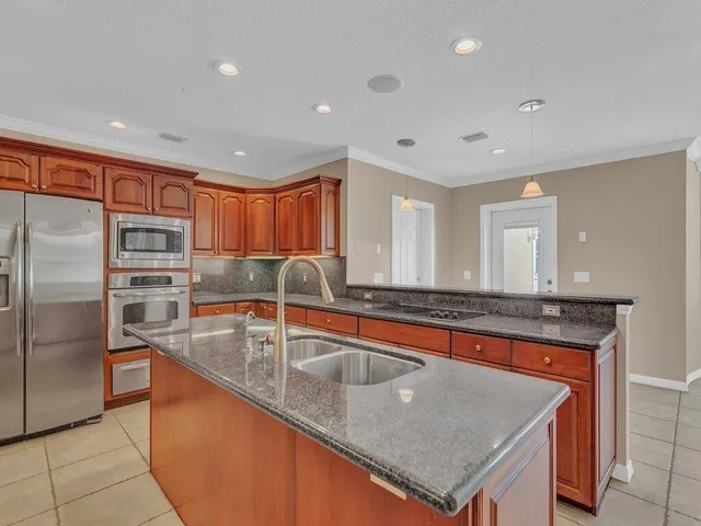 a kitchen with stainless steel appliances granite countertop a sink a stove and a refrigerator