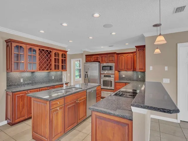 a kitchen with stainless steel appliances granite countertop a sink and a stove
