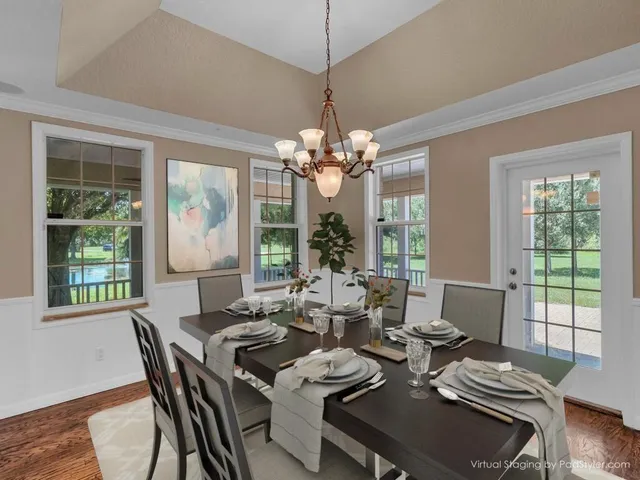 a view of a dining room with furniture a chandelier and wooden floor