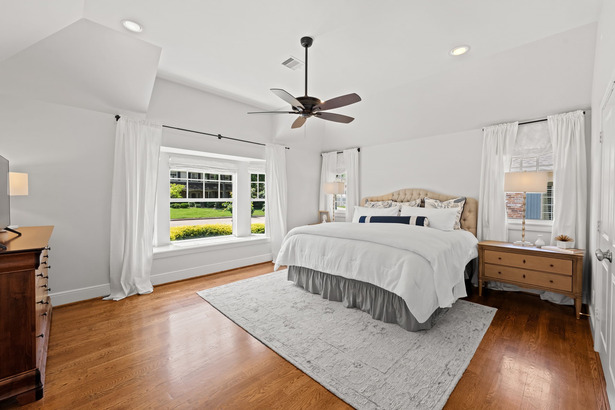 13614 Apple Tree Road Houston, TX 77079 - Photo 9 of 38 a bedroom with a bed lamps and a large window