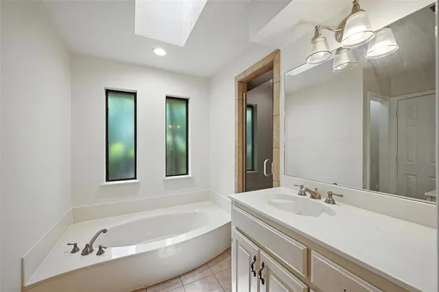 a bathroom with a tub a sink and mirror