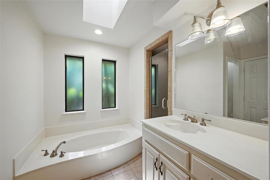 1928 Meandering Way McKinney, TX 75071 - Photo 13 of 22 a bathroom with a tub a sink and mirror