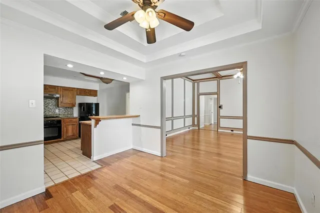 a view of a kitchen with kitchen island wooden floor and a ceiling fan