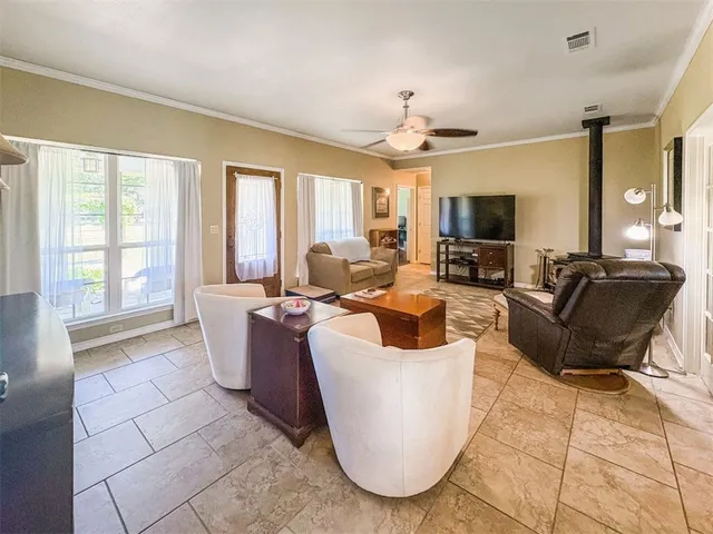 a living room with furniture a flat screen tv and large windows