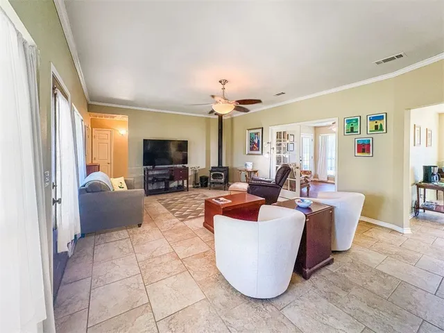 a living room with furniture a flat screen tv and a large window