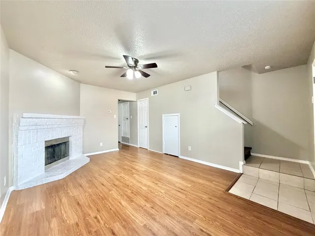 a view of empty room with wooden floor and fireplace
