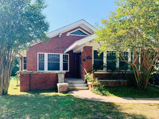 a view of a house with backyard and a tree