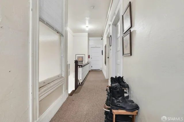 a hallway with front door windows and stairs