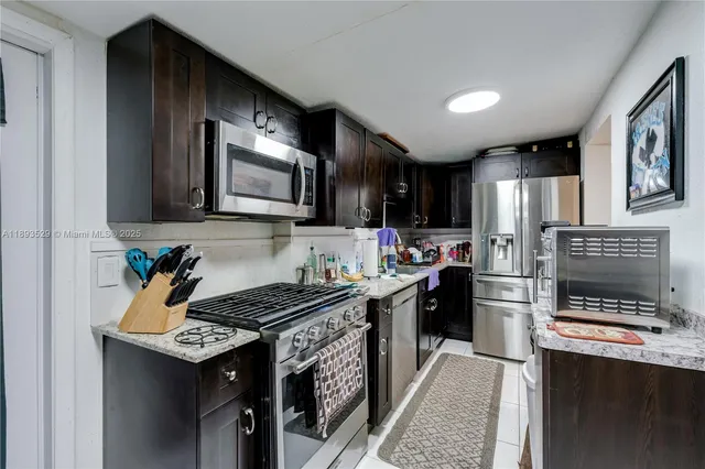 a living room with furniture a flat screen tv and kitchen view