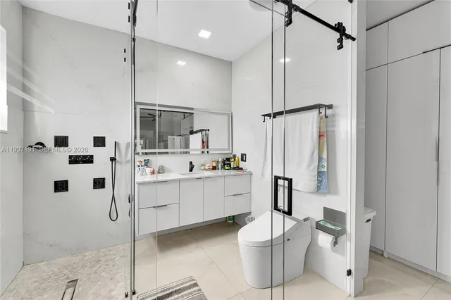 a bedroom with a bed a chair and a flat screen tv