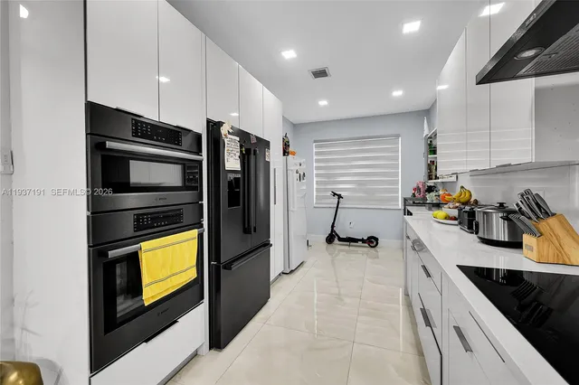 a kitchen with refrigerator and cabinets