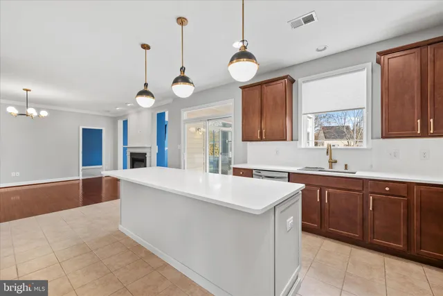 a large kitchen with stainless steel appliances a large center island attached withe living room