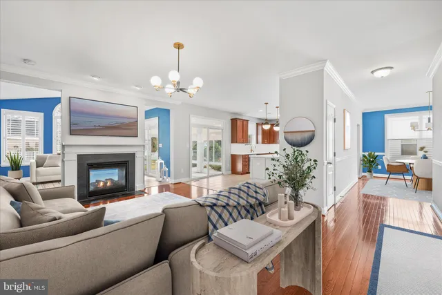 a living room with furniture a chandelier and a fireplace