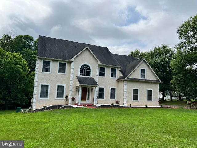 a view of house with a backyard