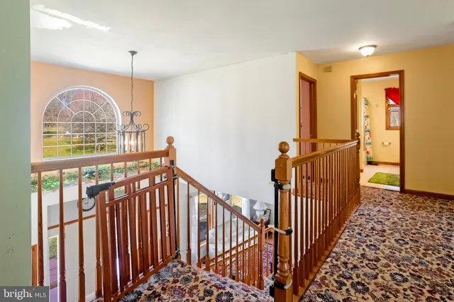 a view of staircase with railing and a chandelier