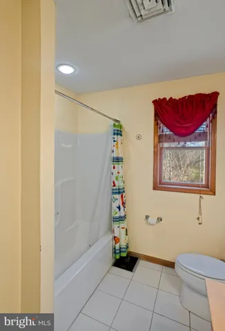 a spacious bathroom with a toilet sink and mirror