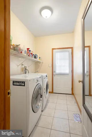 a view of a refrigerator in kitchen and an empty room in wooden floor