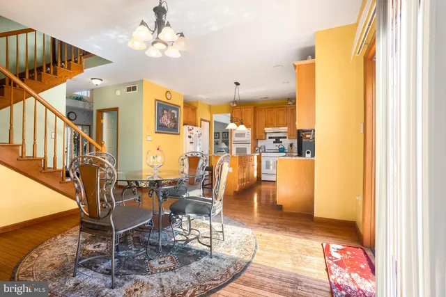 a dining room with furniture a chandelier and wooden floor