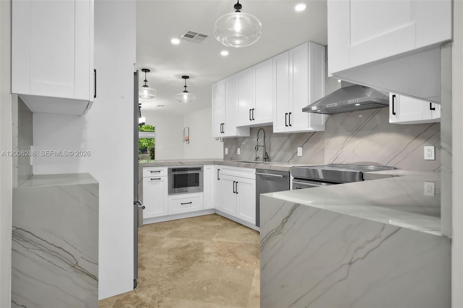 6820 Southwest 86th Avenue Miami, FL 33143 - Photo 11 of 37 a large white kitchen with a stove a sink a refrigerator and a stove