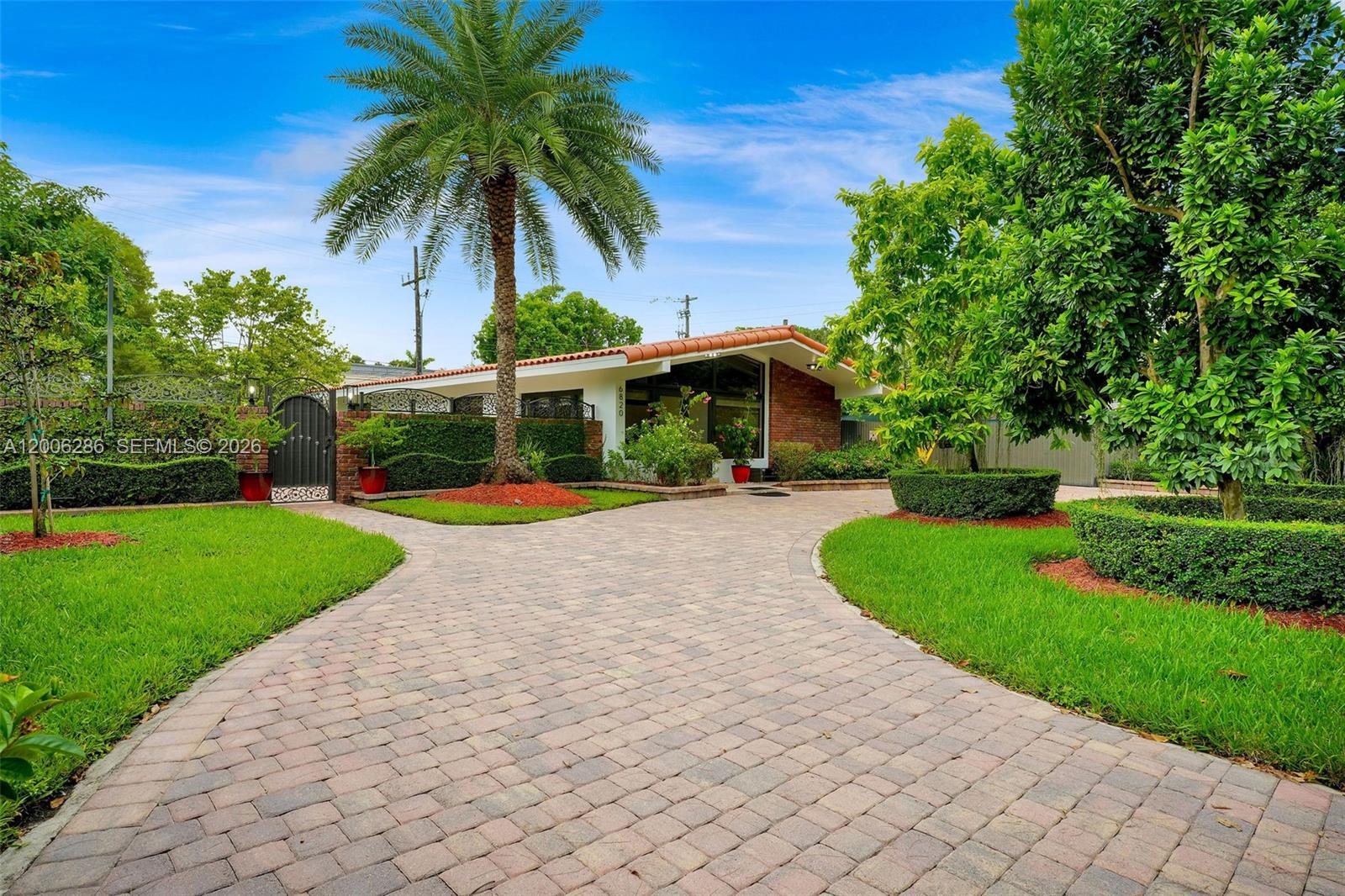 6820 Southwest 86th Avenue Miami, FL 33143 - Photo 2 of 37 a view of a white house with a swimming pool and a yard