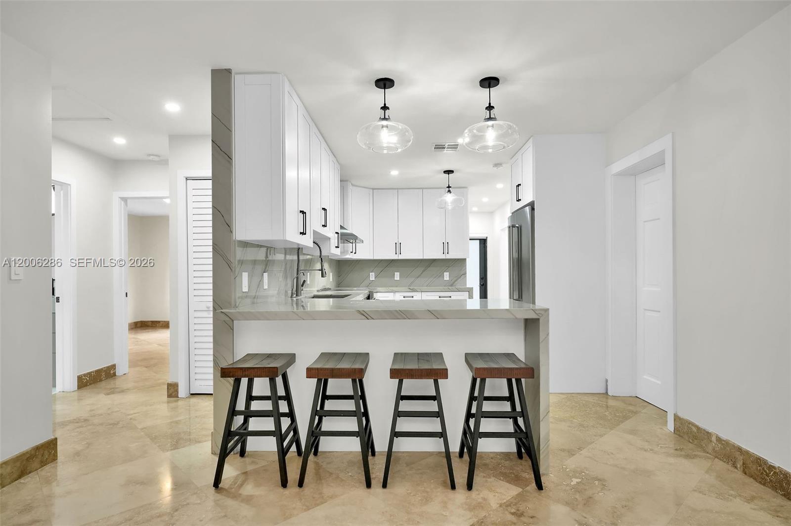 6820 Southwest 86th Avenue Miami, FL 33143 - Photo 8 of 37 a kitchen with kitchen island cabinets and chairs in it