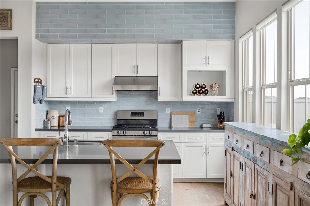 75 Promesa Avenue Rancho Mission Viejo, CA 92694 - Photo 17 of 47 a kitchen with stainless steel appliances kitchen island granite countertop a table chairs in it and wooden floors
