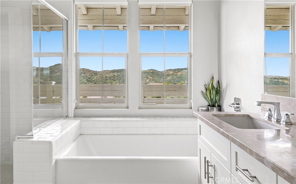 75 Promesa Avenue Rancho Mission Viejo, CA 92694 - Photo 32 of 47 a bathroom with a granite countertop sink and a large mirror next to a window