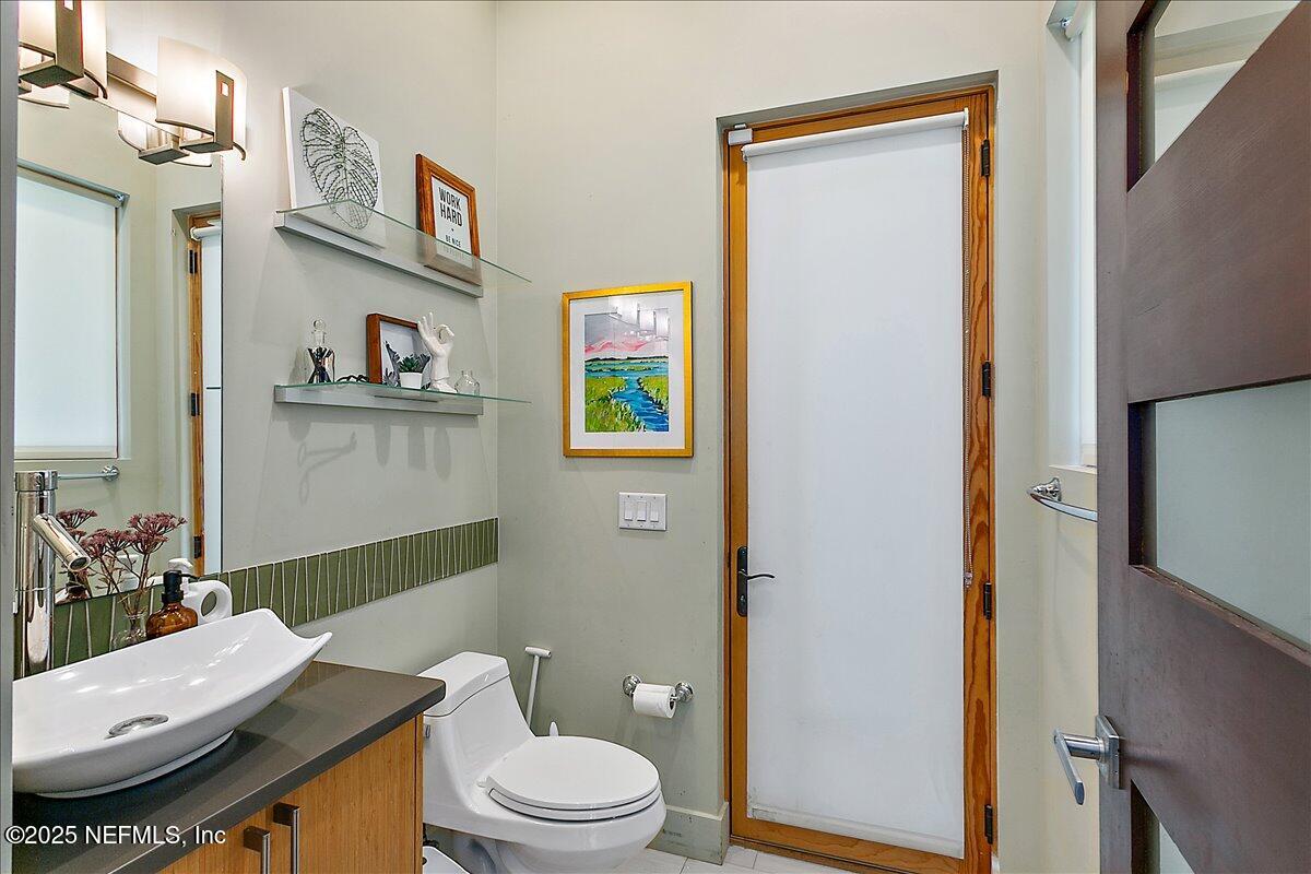 2446 Seminole Road Atlantic Beach, FL 32233 - Photo 12 of 45 a bathroom with a granite countertop toilet sink and a mirror
