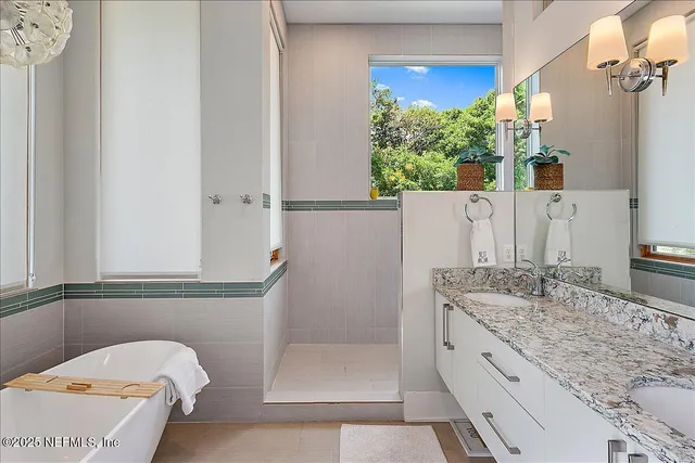 a bathroom with a granite countertop sink a mirror and shower