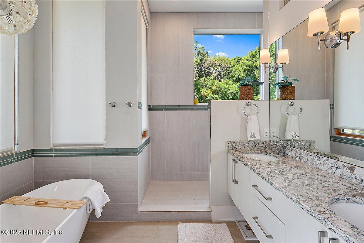 2446 Seminole Road Atlantic Beach, FL 32233 - Photo 15 of 45 a bathroom with a granite countertop sink a mirror and shower