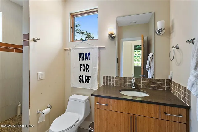 a bathroom with a toilet sink and mirror