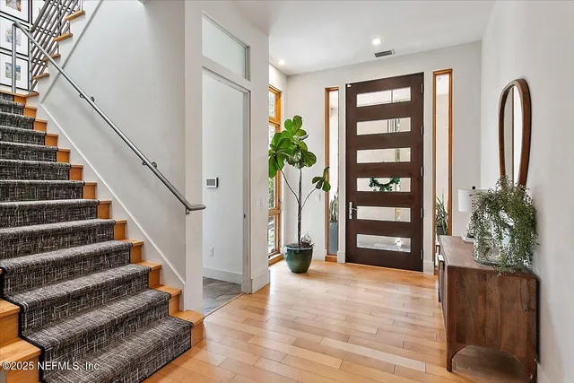 a view of entryway with wooden floor and front door
