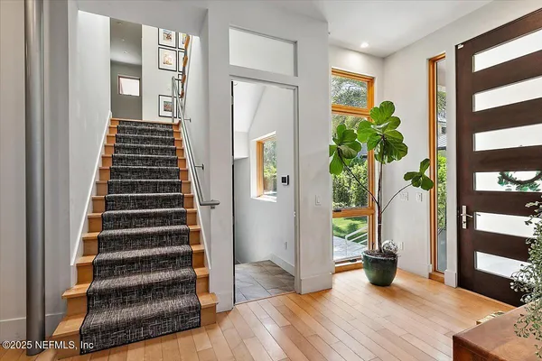 a view of an entryway with wooden floor and stairs