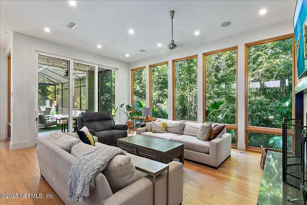 a living room with furniture and floor to ceiling windows