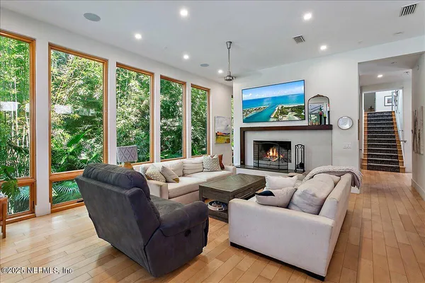 a living room with furniture a fireplace and a large window